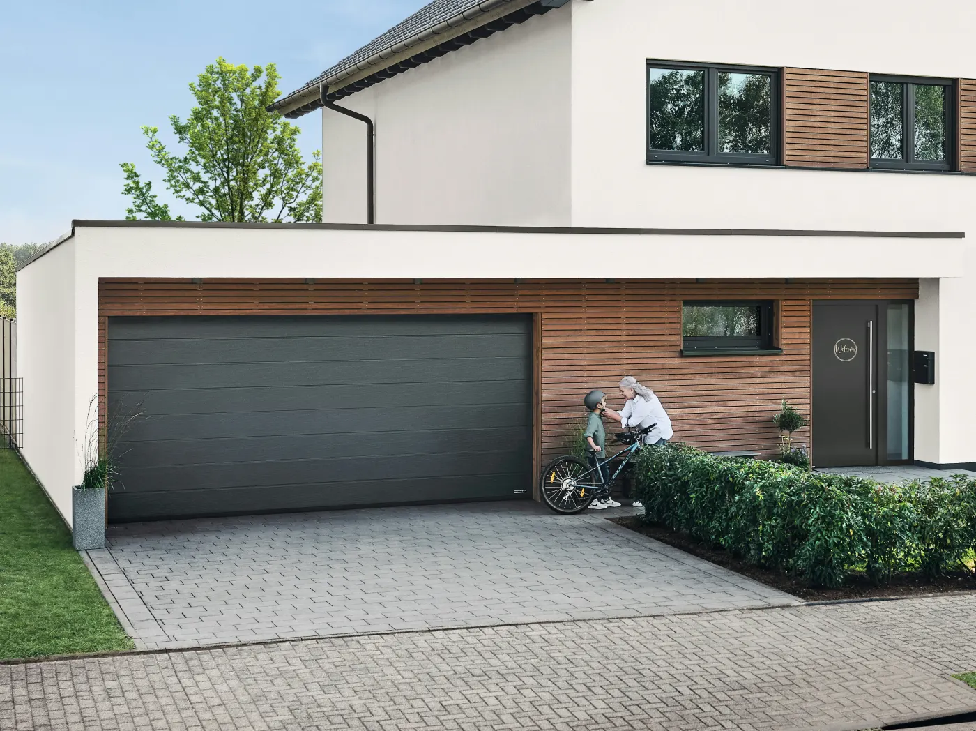 Modernes Einfamilienhaus mit Sektional-Garagentor, Haustür und großen Fenstern