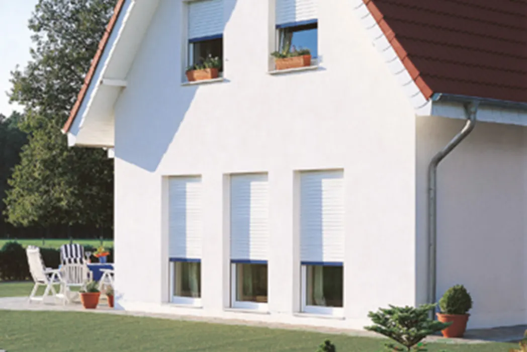 Weißes Einfamilienhaus mit hellen Rollläden