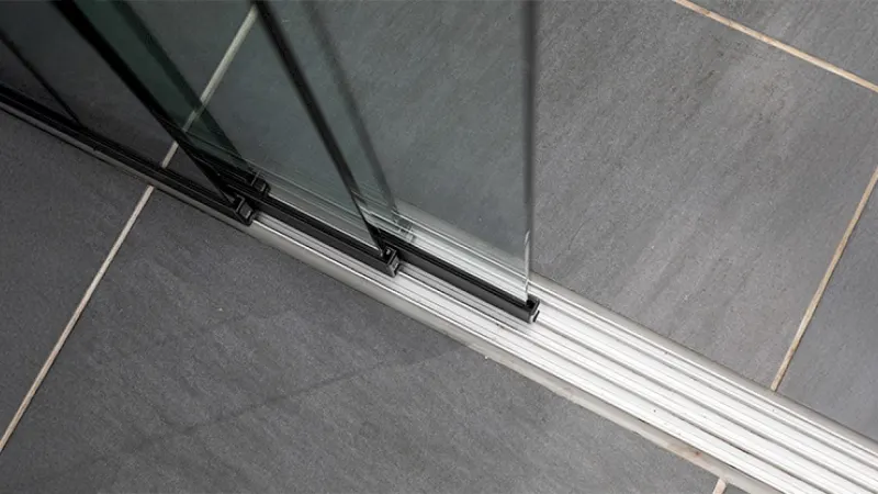 Flache Laufschiene einer Glasschiebewand im Detail